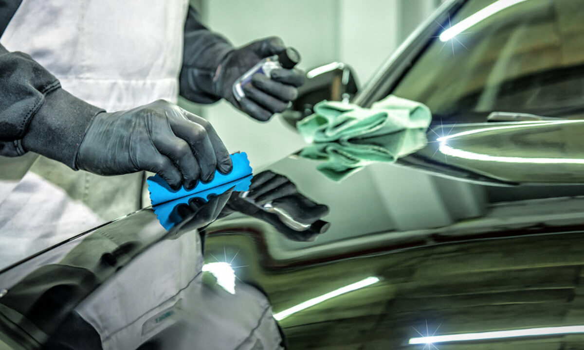 Detailer applying ceramic coating by hand to a panel